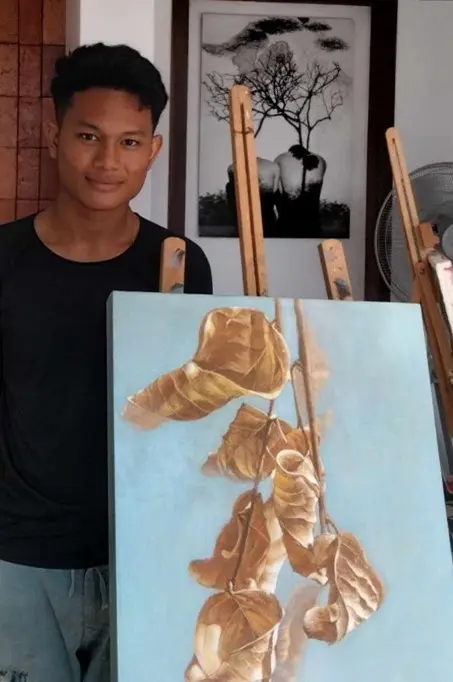 Cambodian artist Karona in his studio presenting a contemporary Khmer painting, SaKa Atelier art gallery Siem Reap